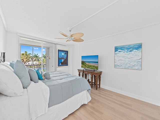 bedroom featuring wood finished floors, baseboards, a textured ceiling, access to outside, and ceiling fan