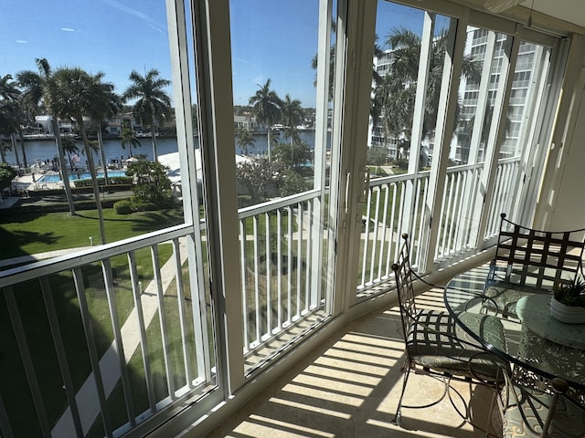 sunroom with a water view and a healthy amount of sunlight