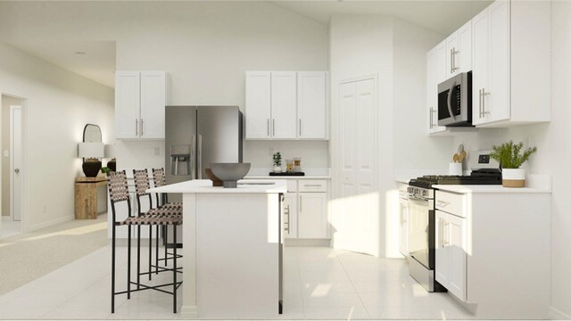 kitchen featuring light countertops, a kitchen island, a kitchen bar, appliances with stainless steel finishes, and white cabinets