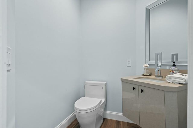 2437 NW 64th St, Boca Raton, FL 33496 - half bathroom with baseboards, toilet, vanity, and wood finished floors