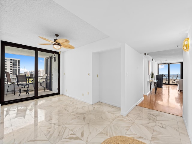 3450 S Ocean Blvd Unit 906, Highland Beach, FL 33487 - unfurnished room featuring ceiling fan, a wall of windows, and baseboards
