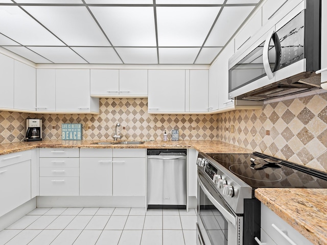 3450 S Ocean Blvd Unit 906, Highland Beach, FL 33487 - kitchen featuring a sink, appliances with stainless steel finishes, white cabinets, decorative backsplash, and light tile patterned floors