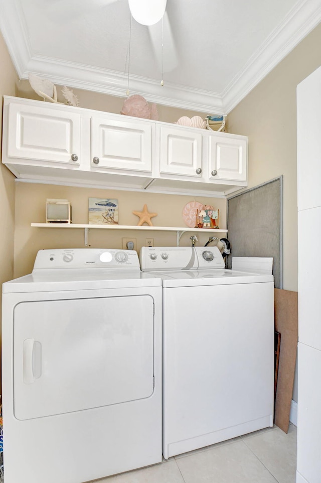 washroom featuring cabinet space, washing machine and clothes dryer, ornamental molding, and light tile patterned floors