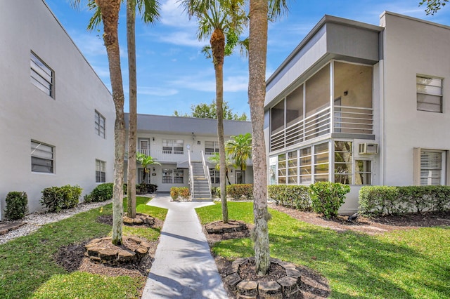 view of home's community featuring a lawn and stairway