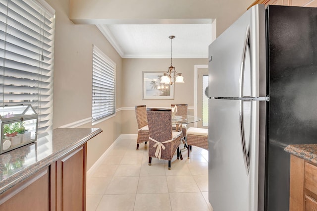 dining room featuring baseboards, crown molding, a chandelier, and light tile patterned flooring