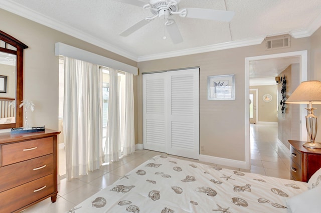bedroom with light tile patterned flooring, a closet, visible vents, and ornamental molding