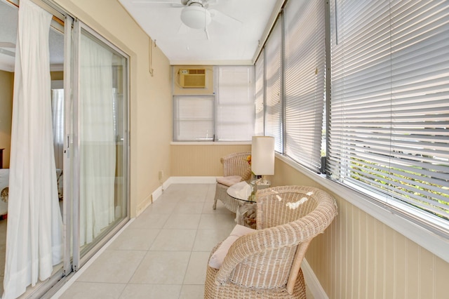 sunroom featuring tile patterned floors, baseboards, and a wall unit AC