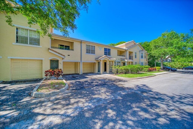 townhome / multi-family property with an attached garage, driveway, and stucco siding
