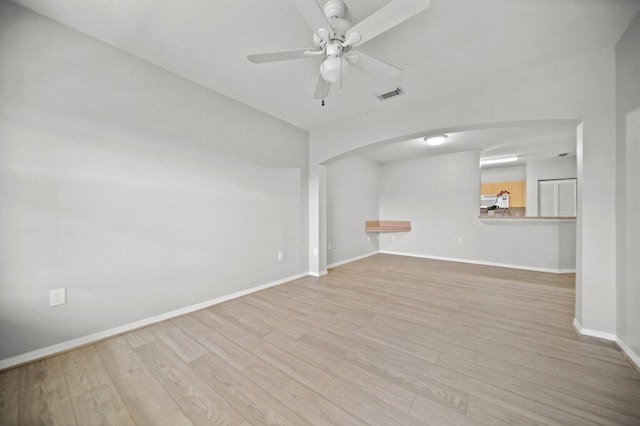 empty room with visible vents, a ceiling fan, baseboards, and wood finished floors