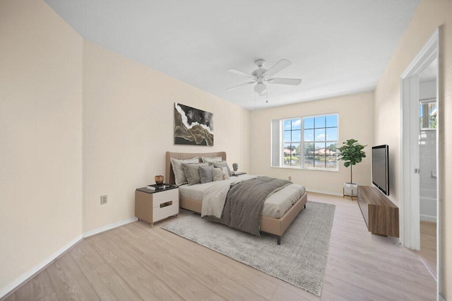 bedroom with baseboards, ceiling fan, and light wood-style flooring