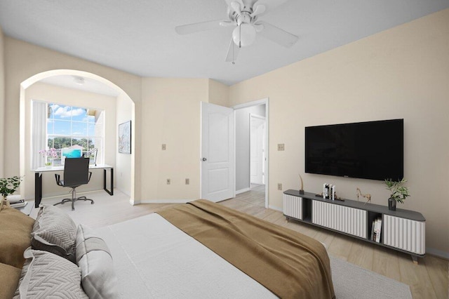 bedroom with arched walkways, baseboards, a ceiling fan, and wood finished floors