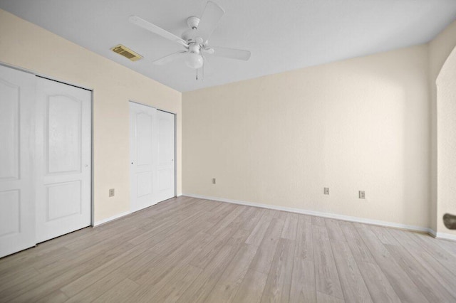 unfurnished bedroom with visible vents, light wood-style flooring, ceiling fan, and baseboards