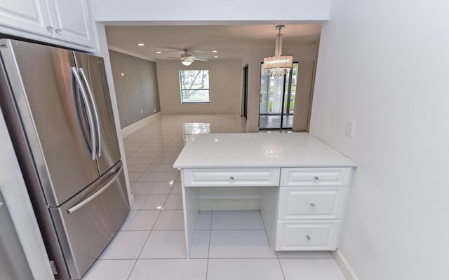 kitchen with freestanding refrigerator, ceiling fan with notable chandelier, light tile patterned floors, and white cabinets