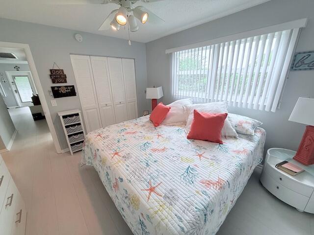 bedroom with a closet, light wood-style flooring, and a ceiling fan