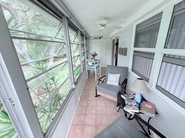 sunroom / solarium featuring a ceiling fan and plenty of natural light