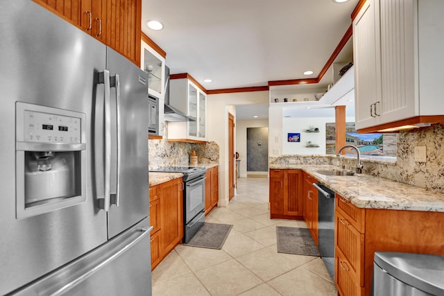 kitchen with light tile patterned floors, glass insert cabinets, light stone countertops, stainless steel appliances, and a sink
