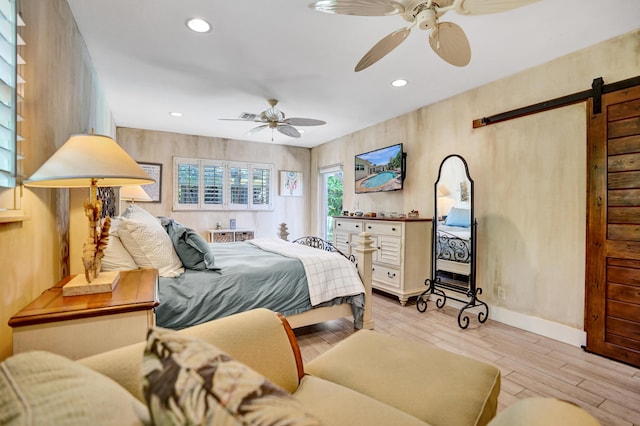 bedroom with recessed lighting, a barn door, ceiling fan, and wood finished floors