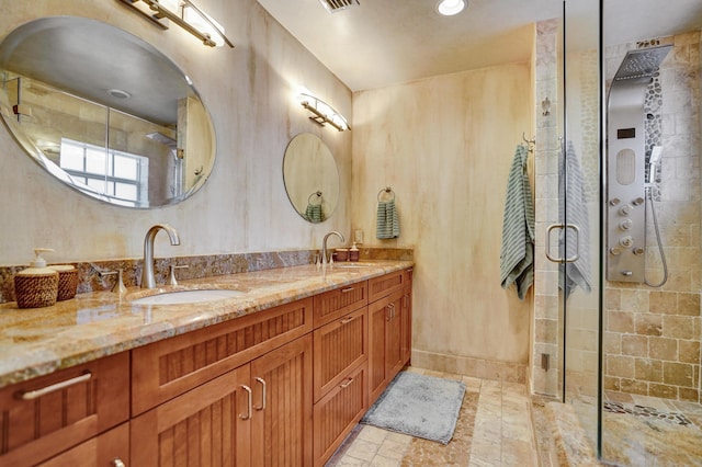 full bathroom featuring a shower stall, double vanity, and a sink