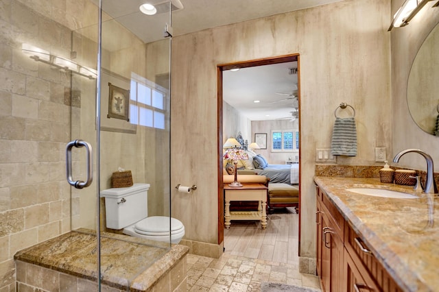 ensuite bathroom featuring ceiling fan, toilet, connected bathroom, vanity, and a stall shower