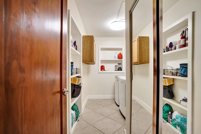 washroom with baseboards, light tile patterned floors, washer and clothes dryer, cabinet space, and built in shelves