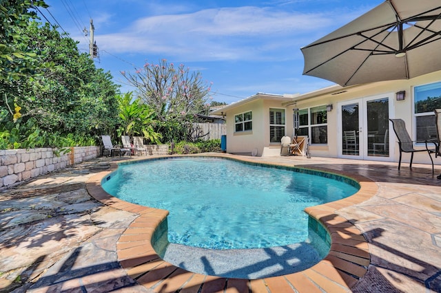 view of swimming pool with a patio area, french doors, fence, and a fenced in pool