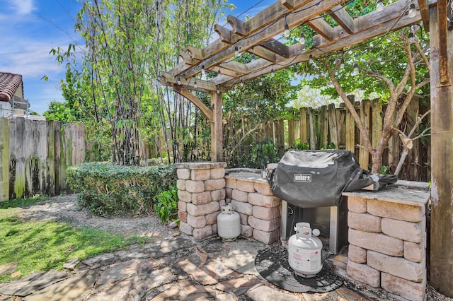 view of patio with a grill, a pergola, and fence