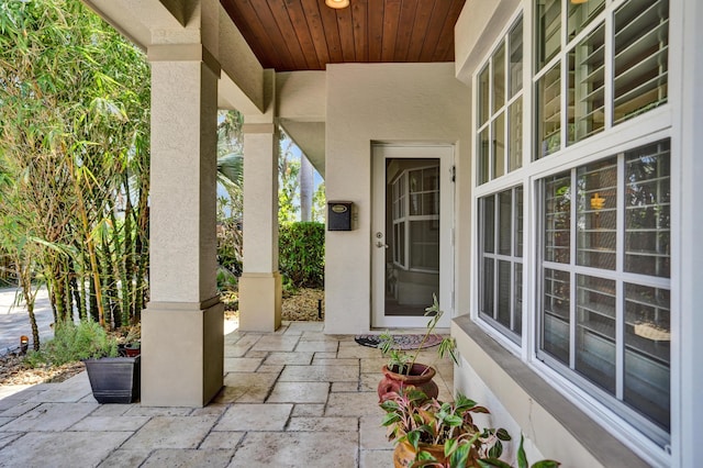 view of exterior entry featuring a patio and stucco siding