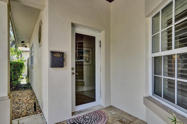 doorway to property featuring stucco siding