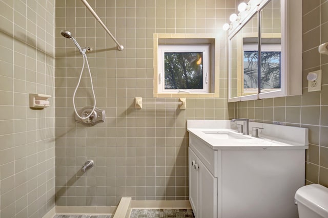 630 Glenridge Dr, West Palm Beach, FL 33405 - full bathroom featuring tile walls, a tile shower, toilet, and vanity
