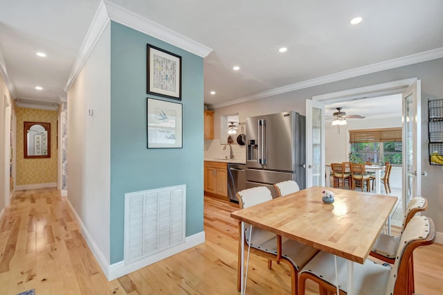 630 Glenridge Dr, West Palm Beach, FL 33405 - dining room featuring light wood finished floors, baseboards, visible vents, and ornamental molding