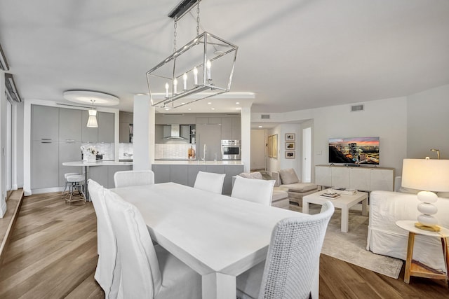 dining space with visible vents and wood finished floors