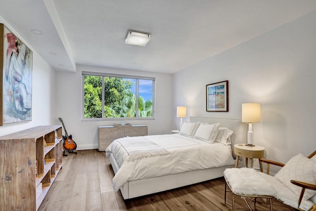 bedroom with baseboards and wood-type flooring