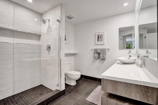 bathroom with a shower stall, baseboards, toilet, and tile patterned flooring
