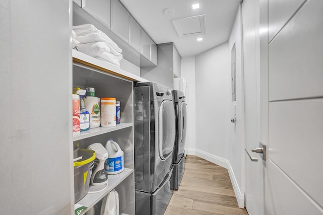 washroom featuring attic access, light wood finished floors, laundry area, baseboards, and independent washer and dryer