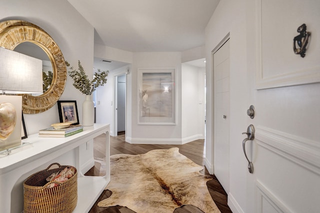 foyer featuring baseboards and wood finished floors