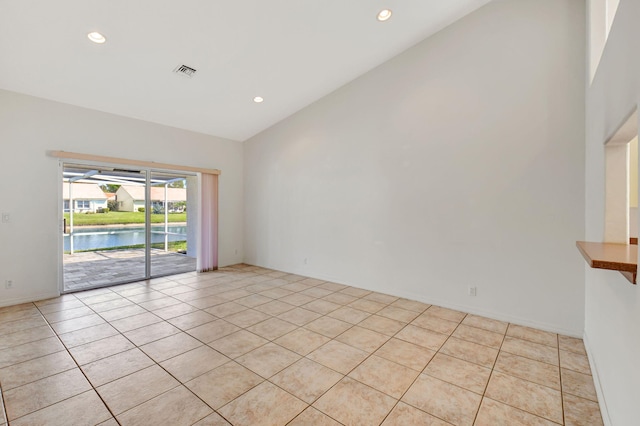 empty room featuring visible vents, high vaulted ceiling, a water view, and recessed lighting