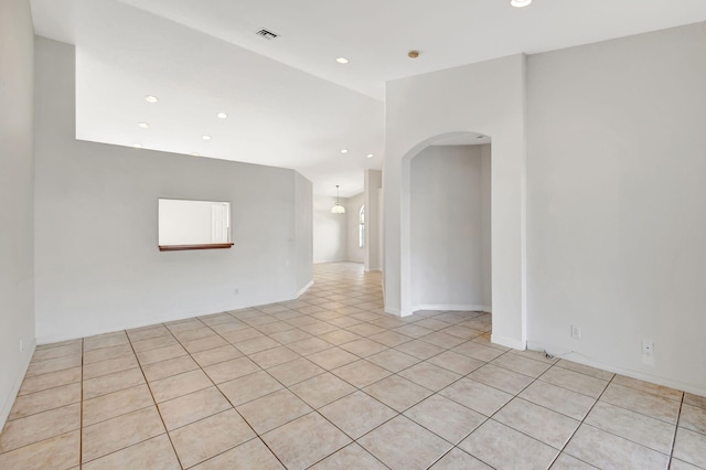 unfurnished room with recessed lighting, arched walkways, and visible vents