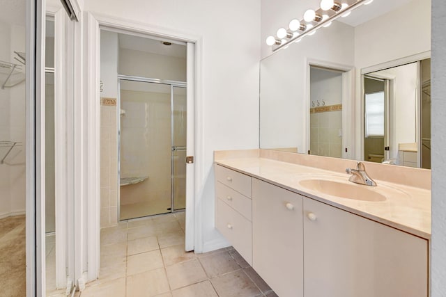 bathroom featuring a stall shower, a spacious closet, and vanity