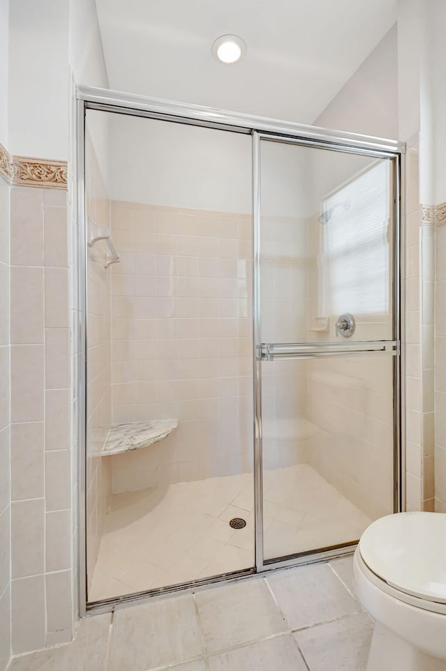 bathroom featuring toilet and a shower stall