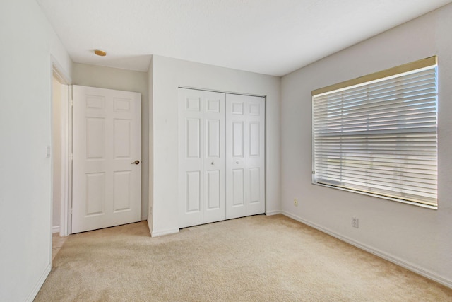 unfurnished bedroom featuring a closet, carpet, and baseboards