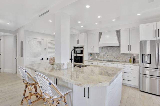 1149 Hillsboro Mile Unit 112N, Hillsboro Beach, FL 33062 - kitchen with visible vents, stainless steel appliances, a sink, custom range hood, and backsplash