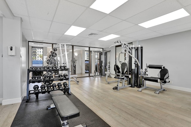 1149 Hillsboro Mile Unit 112N, Hillsboro Beach, FL 33062 - gym featuring baseboards, visible vents, a drop ceiling, and wood finished floors