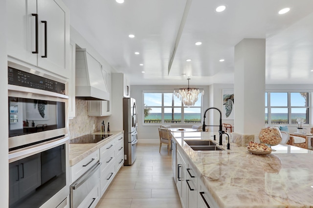 1149 Hillsboro Mile Unit 112N, Hillsboro Beach, FL 33062 - kitchen featuring stainless steel appliances, premium range hood, a sink, a warming drawer, and backsplash