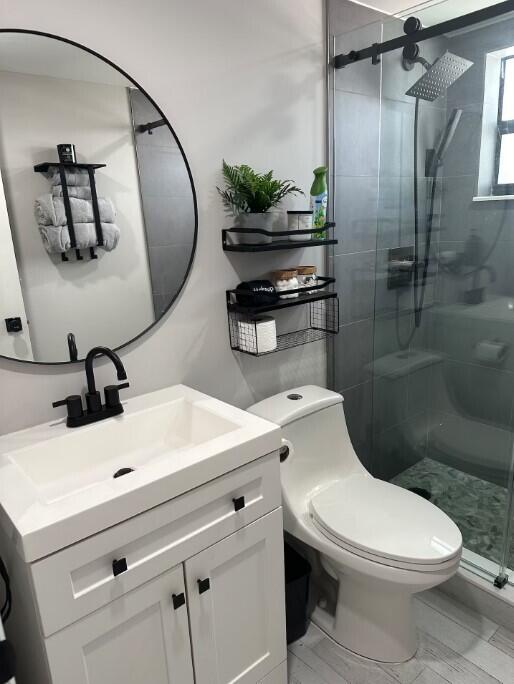 664 SE 20th Ave Unit 1, Deerfield Beach, FL 33441 - bathroom with vanity, toilet, and a stall shower