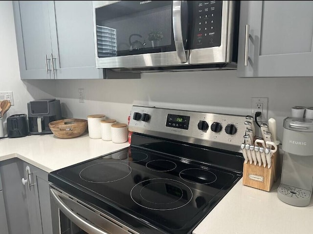 664 SE 20th Ave Unit 1, Deerfield Beach, FL 33441 - kitchen featuring light countertops, gray cabinets, and stainless steel appliances