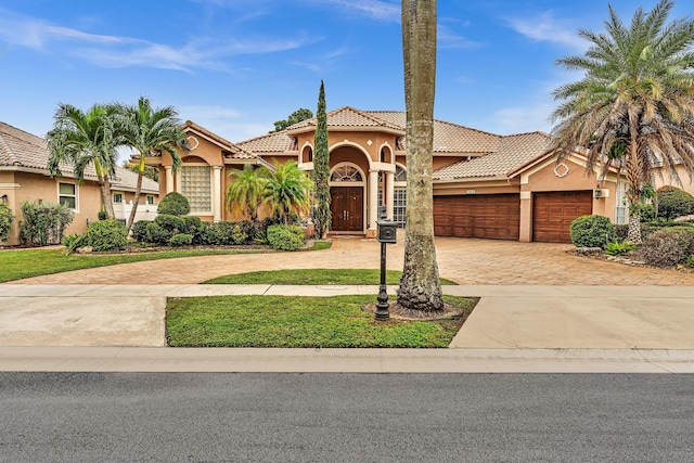 11604 Kensington Ct, Boca Raton, FL 33428 - mediterranean / spanish home with a garage, a front lawn, decorative driveway, stucco siding, and a tiled roof