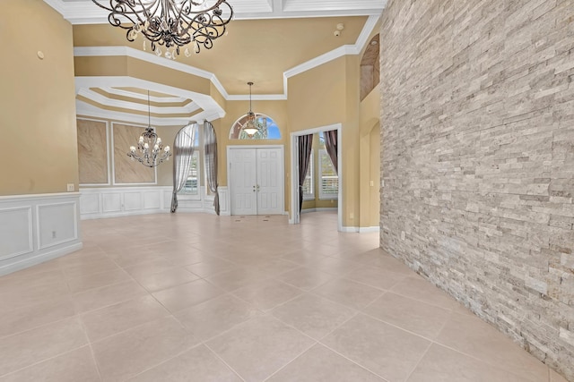 11604 Kensington Ct, Boca Raton, FL 33428 - tiled entrance foyer with crown molding, a wainscoted wall, a decorative wall, and a notable chandelier