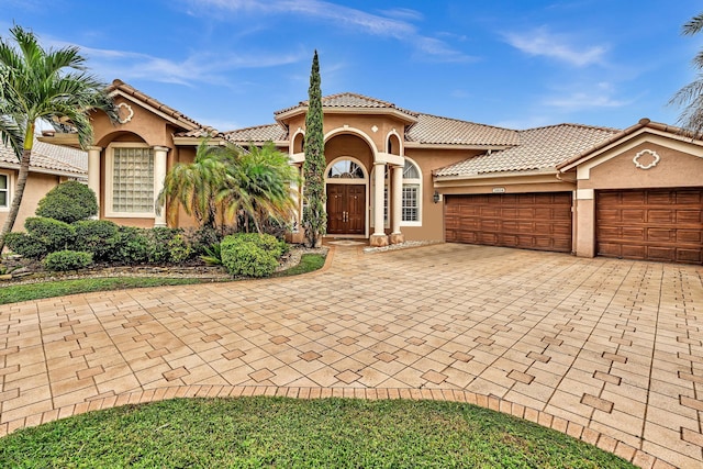 11604 Kensington Ct, Boca Raton, FL 33428 - mediterranean / spanish-style home with decorative driveway, a garage, a tile roof, and stucco siding