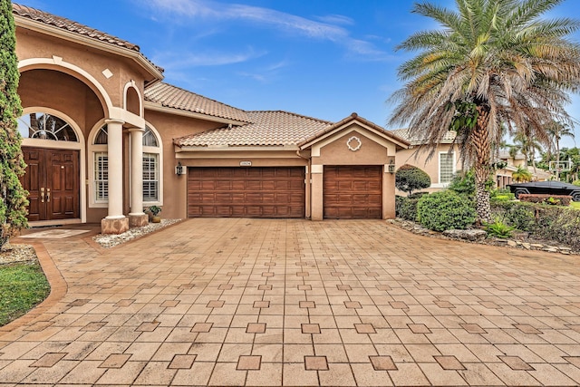 11604 Kensington Ct, Boca Raton, FL 33428 - mediterranean / spanish-style house with an attached garage, decorative driveway, stucco siding, and a tiled roof