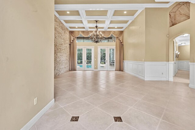 11604 Kensington Ct, Boca Raton, FL 33428 - spare room with a towering ceiling, arched walkways, light tile patterned floors, a notable chandelier, and coffered ceiling
